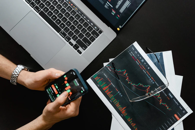 Homme suivant les cours de bourse sur son téléphone
