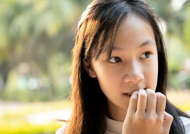 Anxious child bites her fingernails