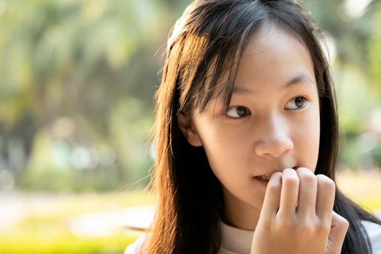 Anxious child bites her fingernails