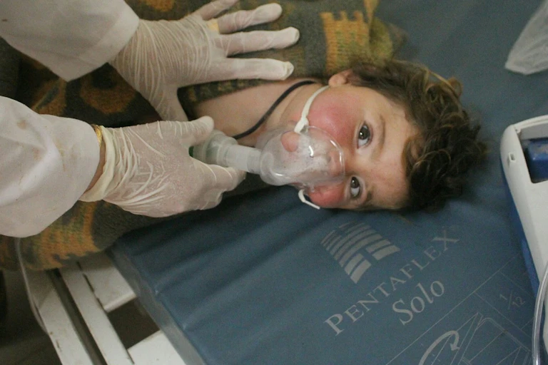 doctor holds mask to face of child