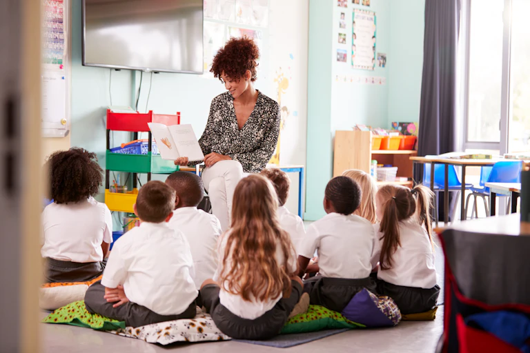 Teacher reads to a class of primary students.