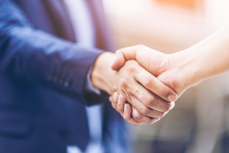 Close up hand of business person shaking hands with partner, fair play.