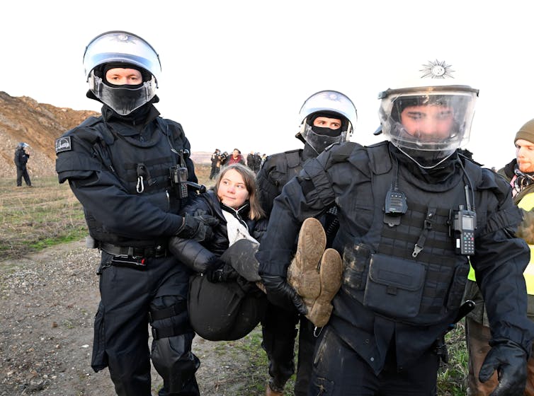Three police carry woman
