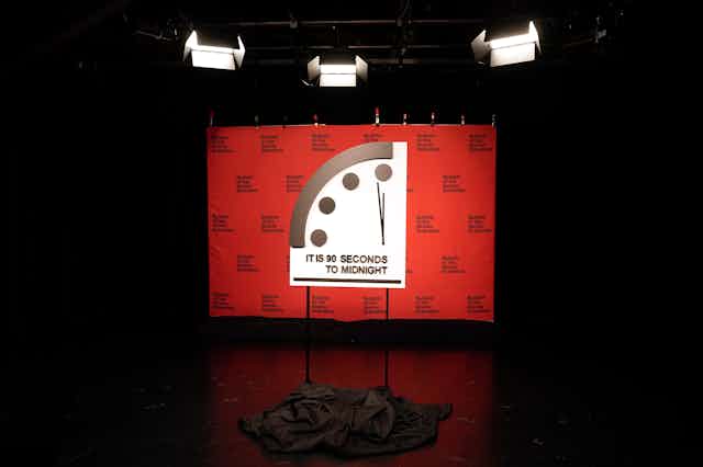 a large display showing the top-lefthand corner of a clock with the text IT IS 90 SECONDS TO MIDNIGHT