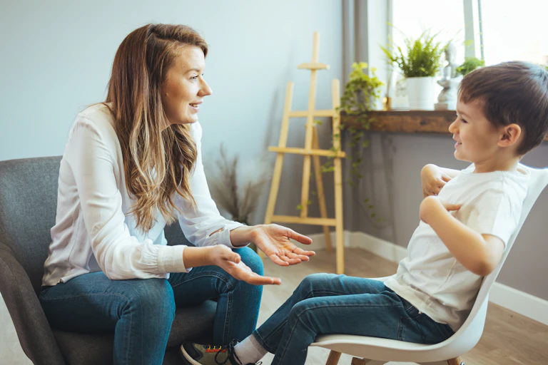 woman sits opposite young boy and they talk
