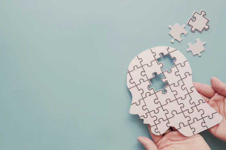A puzzle shaped like a human head with pieces missing
