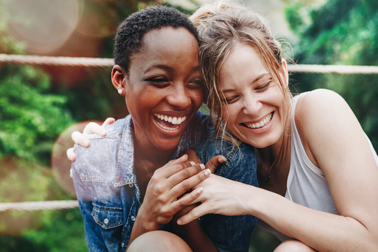 Two joyful women embracing each other.