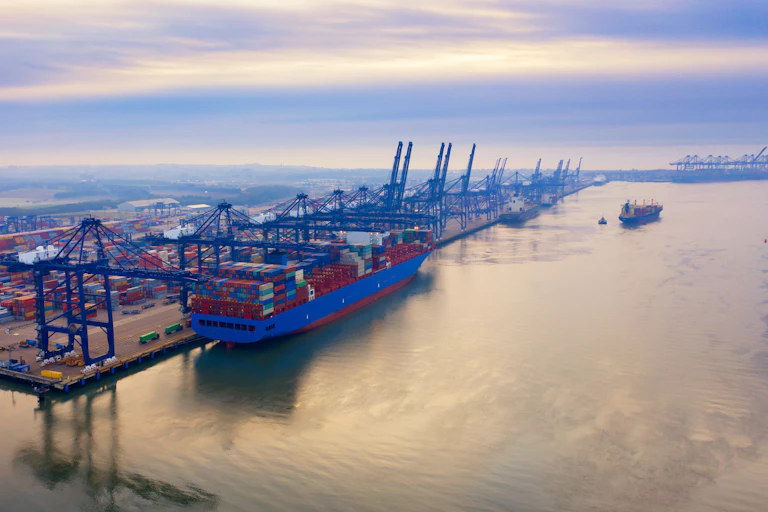 A port with ships and cargo cranes at dawn