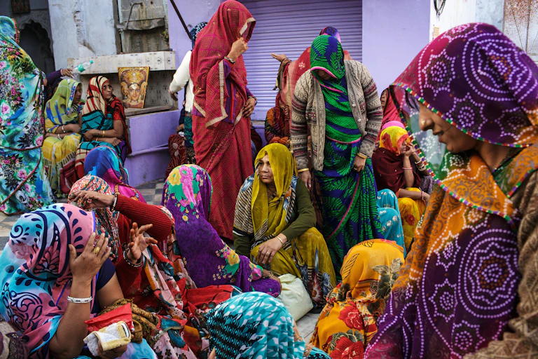 A group of colourfully dressed women mourning a death in India.