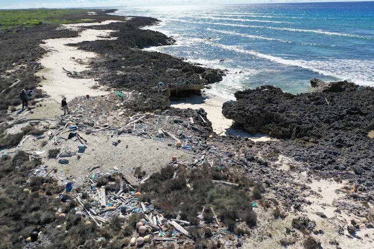 An aerial shot of a group of people removing litter from a beach.