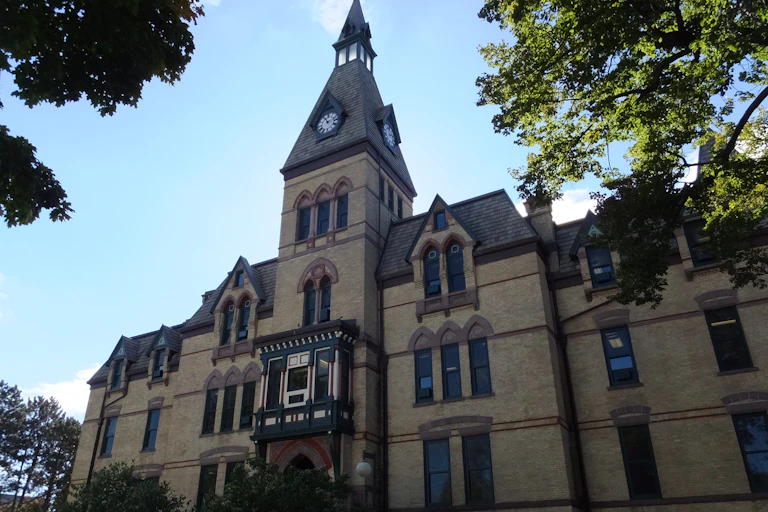 Photograph of a university building with large windows and a clock tower.