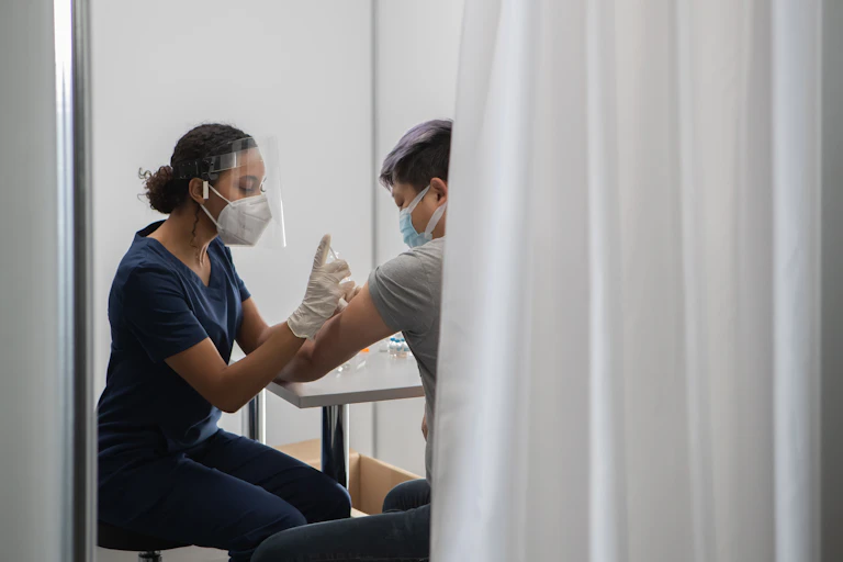 A healthcare worker administers a vaccination.