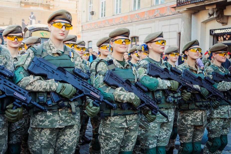 Women soldiers carrying machine guns.