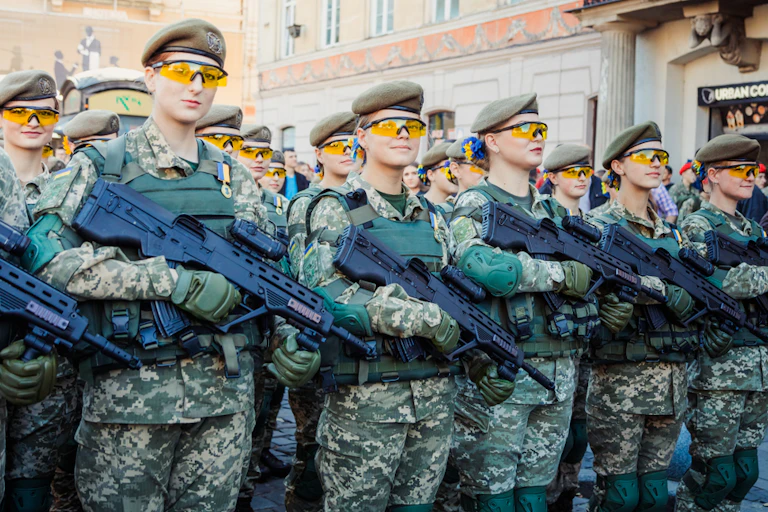 Women soldiers carrying machine guns.