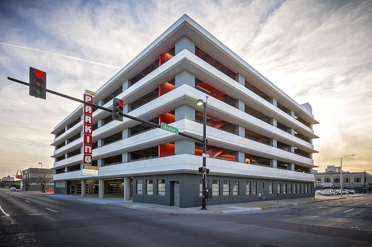 View of white concrete parking garage from street.