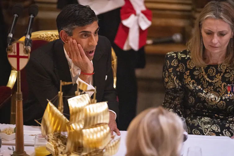 Rishi Sunak looking surprised at a black tie dinner.