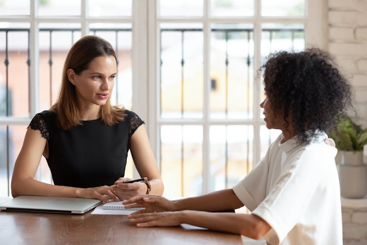 Two women sitting and talking at a conference table