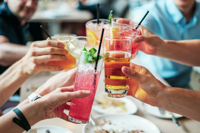 Hands raising cocktails in a toast
