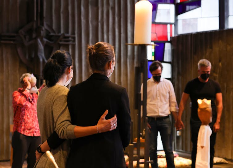 Two same-sex couples stand in a church.