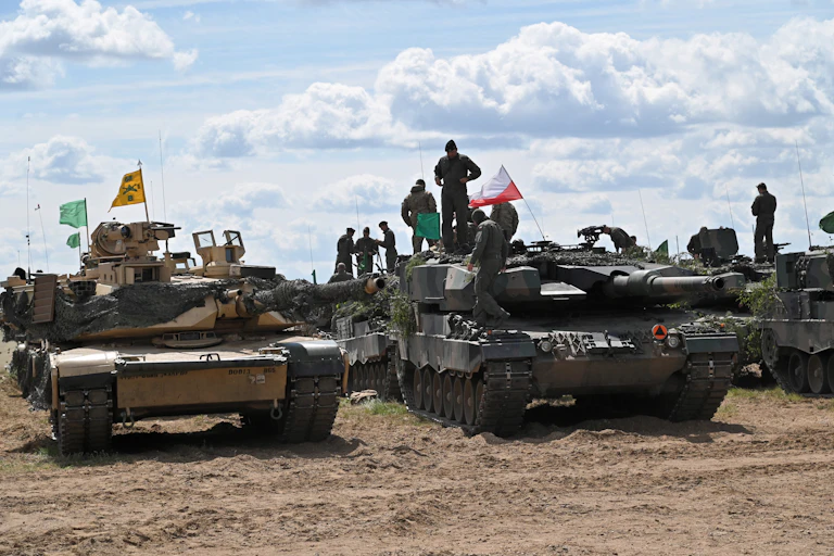 Abrams and Leopard tanks with their crews.