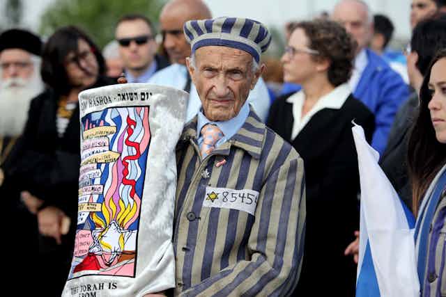 An elderly man in the foreground holding up a banner.
