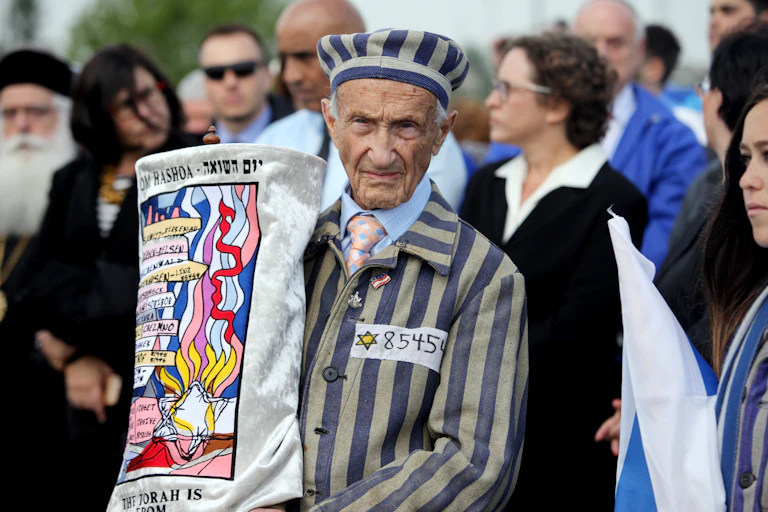 An elderly man in the foreground holding up a banner.