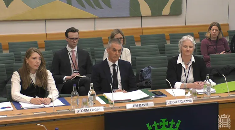 Tim Davie, flanked by two senior BBC executives, sit behind a desk at the pubilc accounts committee in parliament.