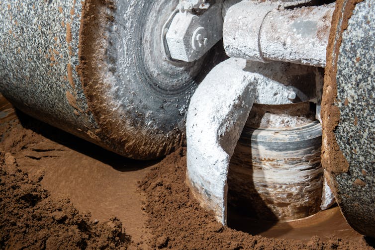 millstones of an industrial machine smashing cocoa powder