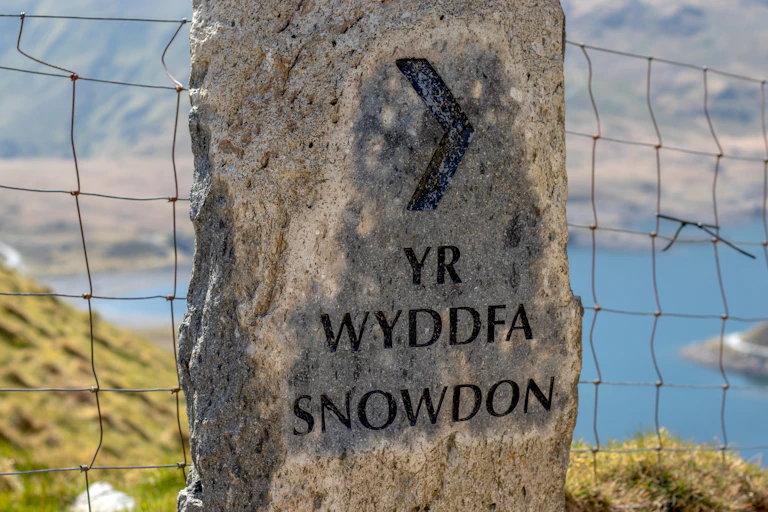 Large rock with printed words 'Yr Wyddfa' and 'Snowdon' printed on it