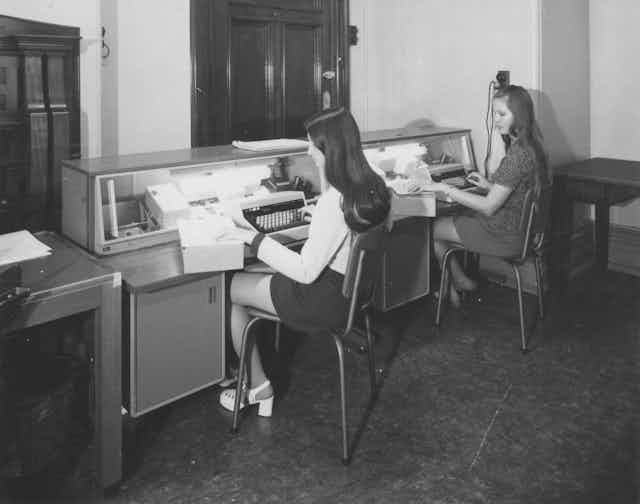 Two women in the 1970s at typewriters