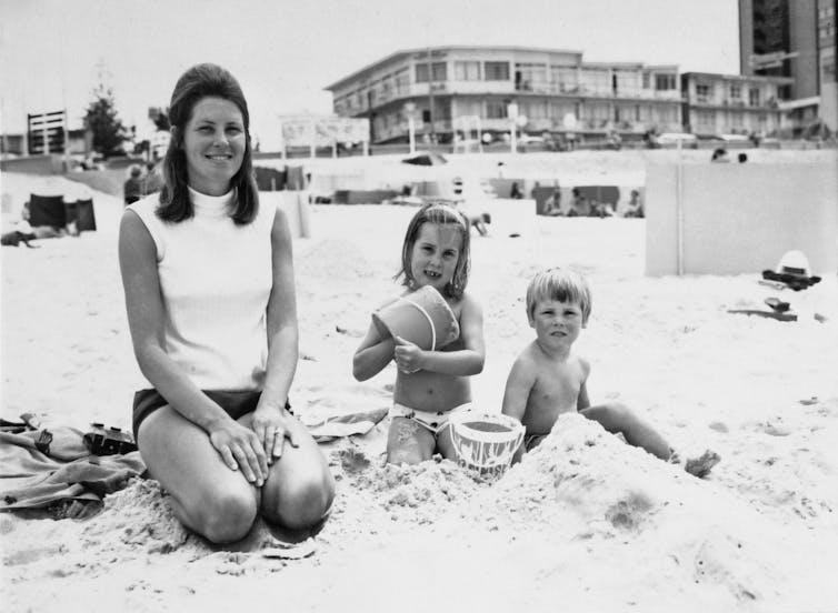 A mother and two children at a beach.