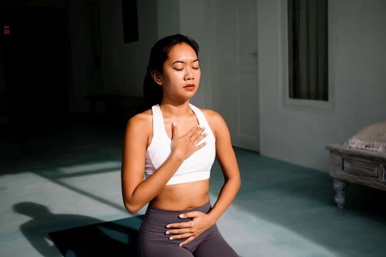 une jeune femme asiatique est en position de méditation/yoga
