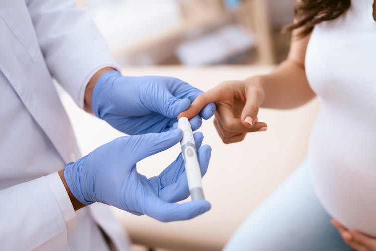 Pregnant woman having her blood sugar tested