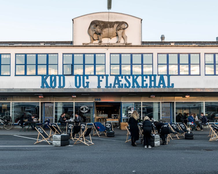The outside of a restaurant with a relief of a steer above the entrance.