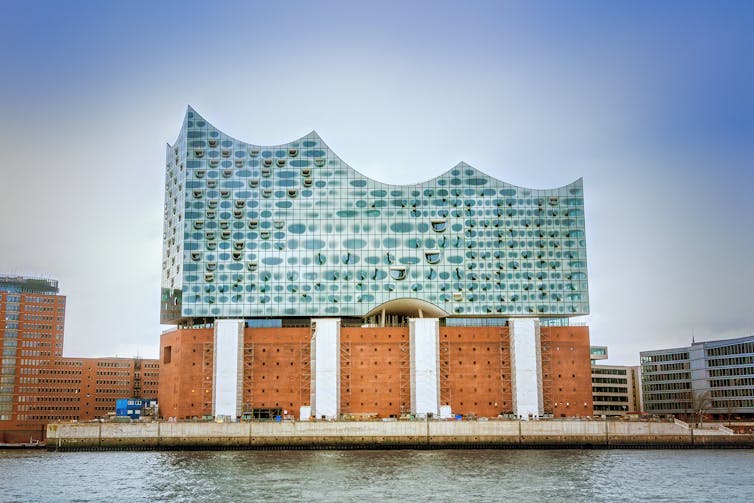 A glass and red brick building seen from the side.