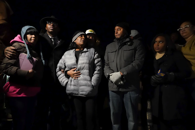 People in warm clothes stand together outside