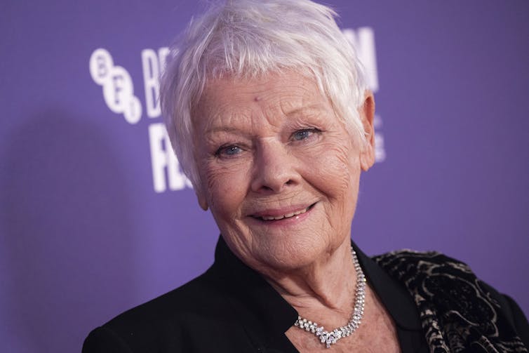 older woman with short hair poses for photo on red carpet