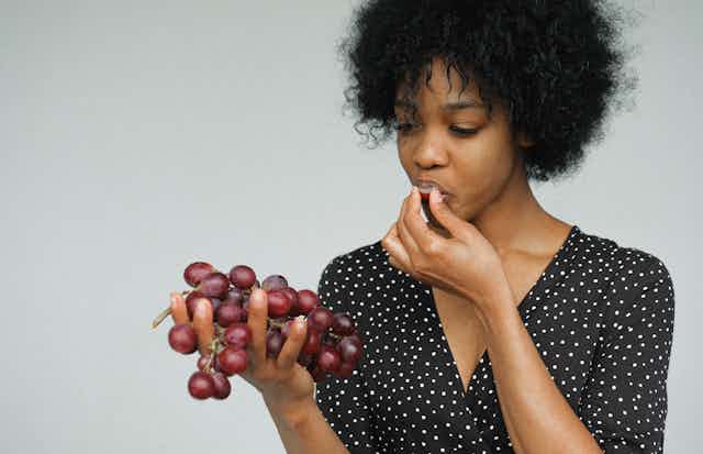 African-Australian woman eats grapes
