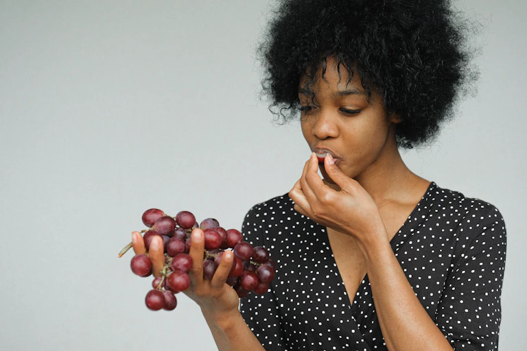 African-Australian woman eats grapes