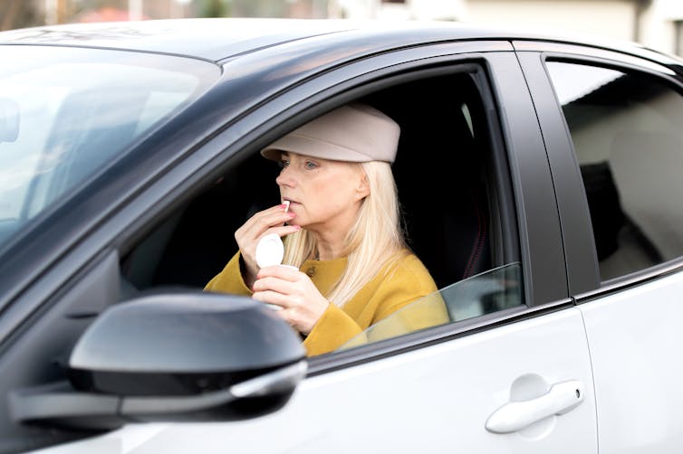 Middle-aged woman eats chewing gum in the car