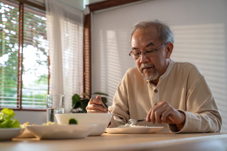 Older man eats rice