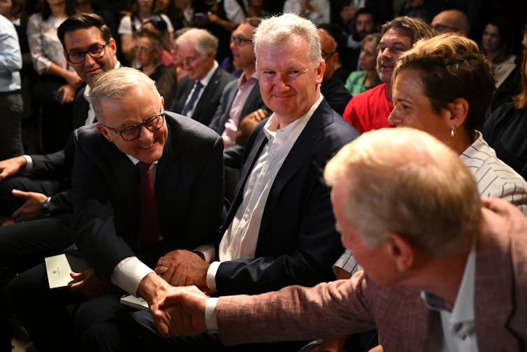 The prime minister and the arts minister sit and smile.