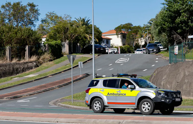 ambulance drives on suburban street
