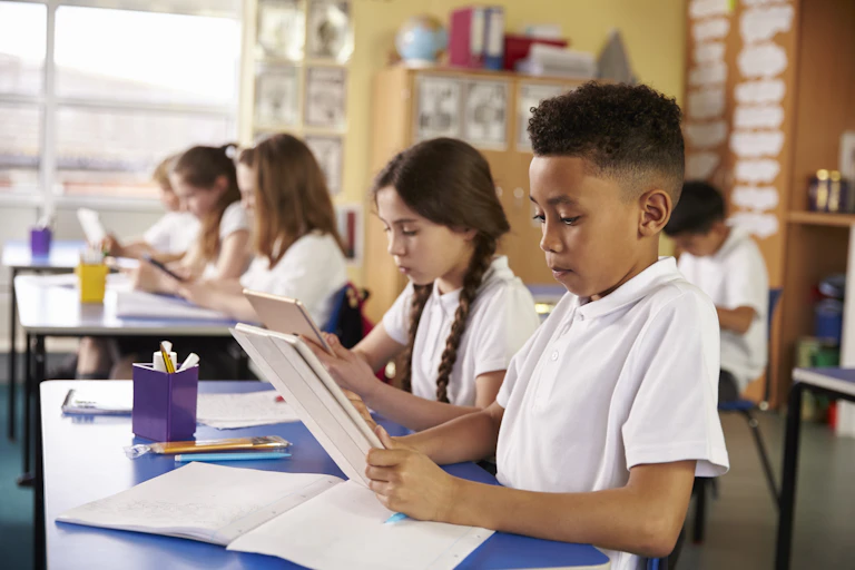 Children using tablets in a classroom.