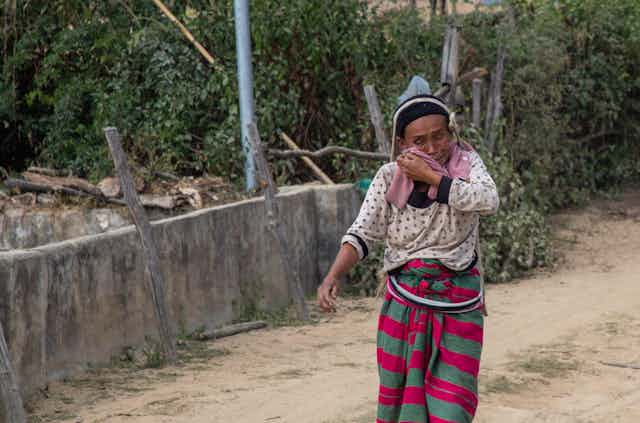A Burmese womanfrom the Shan minority cries as she flees along a road.