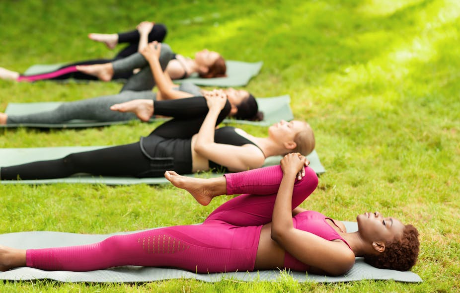 A group of women stretching their leg during yoga class 