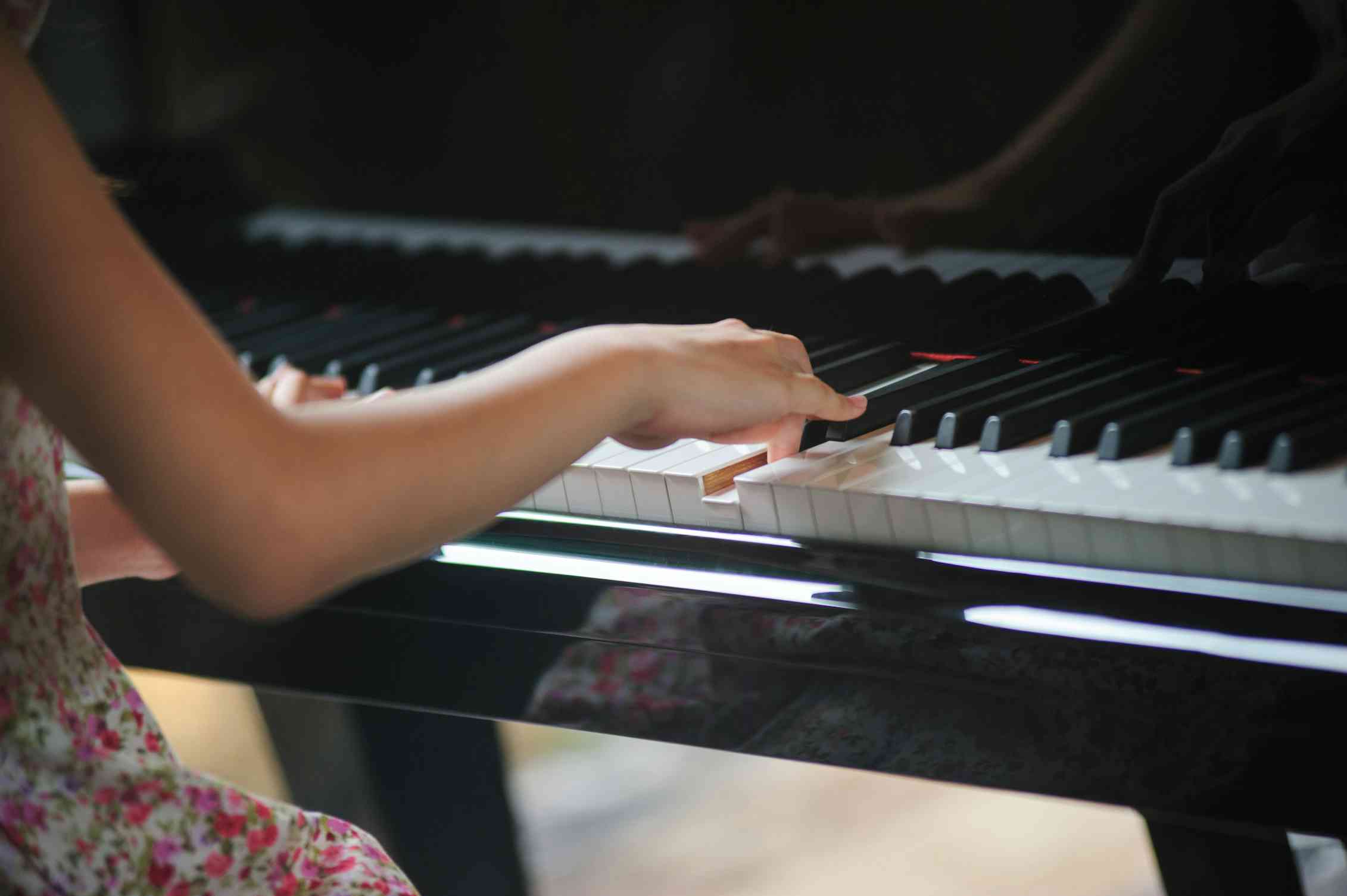 A child's hands on a piano.