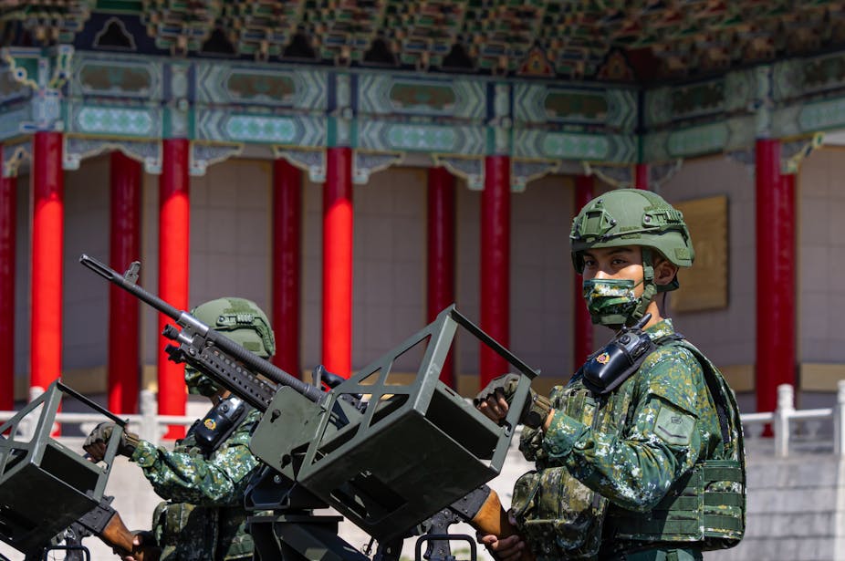 Militaires taïwanais en uniforme devant des mitrailleuses dans un palais