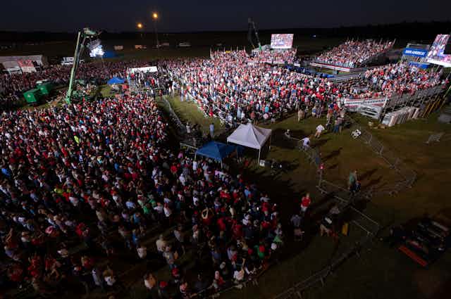 A crowd gathers on a grass field.
