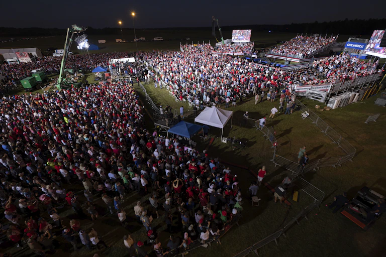 A crowd gathers on a grass field.